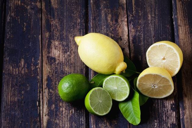 Whole and sliced lemons and limes on dark wood  CSF026647