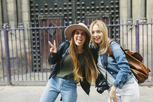 Spain, Barcelona, two playful young women in front of entrance portal  EBSF000935