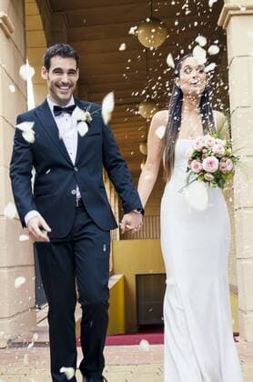 Bridal couple after the wedding under rain of rose petals and rice grains  GEMF000460