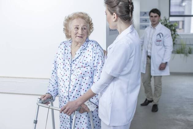 Model Released: Senioren im Krankenhaus Nurse leading elderly patient with walking frame on hospital floor model released Symbolfoto property released  ZEF007271