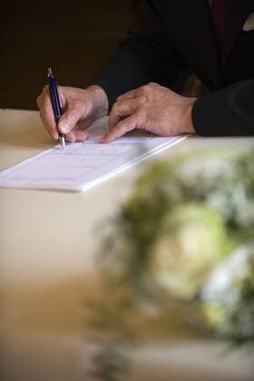 Standesamtliche Hochzeit, Braeutigam unterschreibt Heiratsurkunde am Standesamt married in a civil ceremony BLWS241199