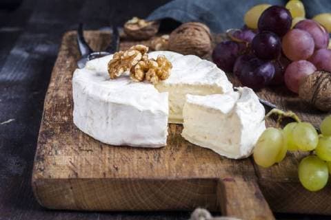 Wooden board with sliced camembert, walnuts and grapes  SBDF002575