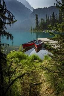 brightly colored canoes tied to a dock at Lake O Hara in Yoho National Park in the Canadian Rockies  acp91473 Photography