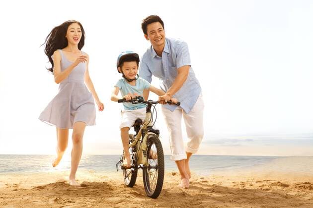Family on beach riding bicycle  cpmh-95620f06z