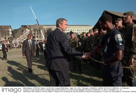 IMAGO History, Anschläge vom 11. September aus New York und Washington D.C 20 Jahre Anschläge vom 11. September: Attentat auf das Pentagon Sept. 12, 2001 - Pentagon, VIRGINIA, UNITED STATES OF AMERICA - US President George W. Bush greets rescue workers and military personnel in front of the damaged Pentagon September 12, 2001 in Arlington, VA. On September 11th American Airlines Flight 77 hijacked by terrorists fly into the building killing all 64 passengers onboard and 125 people on the ground. Pentagon UNITED STATES OF AMERICA - ZUMAp138