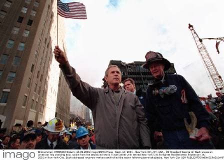 IMAGO History, Anschläge vom 11. September aus New York und Washington D.C 20 Jahre Anschläge vom 11. September: World Trade Center Sept. 14, 2001 - New York City, NY, USA - US President George W. Bush waves an American flag standing atop rubble from the destroyed World Trade Center with retired New York City firefighter Bob Beckwith September 14, 2001 in New York City. Bush addressed recovery workers and rallied the nation following terrorist attacks. New York City USA - ZUMAp138