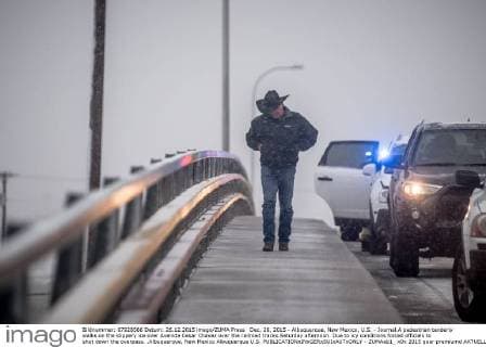 Dec. 26, 2015 - Albuquerque, New Mexico, U.S. - Journal.A pedestrian tenderly walks on the slippery ice over Avenida Cesar Chavez over the railroad tracks Saturday afternoon. Due to icy conditions forced officials to shut down the overpass. .Albuquerque, New Mexico Albuquerque U.S. - ZUMAab1_