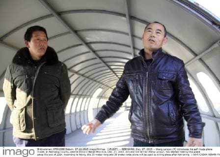 (151227) -- NEIHUANG, Dec. 27, 2015 -- Wang Lanqun (R) introduces his self-made plane model, in Neihuang County, central China s Henan Province, Dec. 27, 2015. 61-year-old farmer Wang Lanqun, has started making this plane since the end of 2014. According to Wang, the 35-meter-long and 38-meter-wide plane will be used as dining place after furnishing. ) (dhf) CHINA-HENAN-FARMER-PLANE MODEL (CN) LiuxXiaokun 