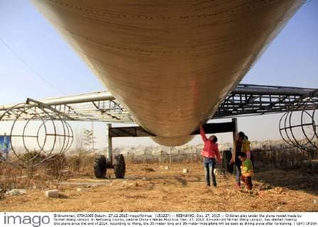 (151227) -- NEIHUANG, Dec. 27, 2015 -- Children play under the plane model made by farmer Wang Lanqun, in Neihuang County, central China s Henan Province, Dec. 27, 2015. 61-year-old farmer Wang Lanqun, has started making this plane since the end of 2014. According to Wang, the 35-meter-long and 38-meter-wide plane will be used as dining place after furnishing. ) (dhf) CHINA-HENAN-FARMER-PLANE MODEL (CN) LiuxXiaokun 