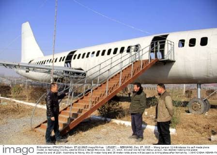 (151227) -- NEIHUANG, Dec. 27, 2015 -- Wang Lanqun (L) introduces his self-made plane model, in Neihuang County, central China s Henan Province, Dec. 27, 2015. 61-year-old farmer Wang Lanqun, has started making this plane since the end of 2014. According to Wang, the 35-meter-long and 38-meter-wide plane will be used as dining place after furnishing. ) (dhf) CHINA-HENAN-FARMER-PLANE MODEL (CN) LiuxXiaokun 