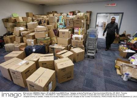 Kanada: syrische Flüchtlinge in Toronto erhalten Hilfe Dec. 27, 2015 - Toronto, ON, Canada - TORONTO, ON - DECEMBER 27: Aquil Januwalla is dwarfed by a mountain of boxes that have been sorted and will go to Syrian refugees coming to Canada. Friends of Syria also hosted a dinner for refugees at the Toronto Port Authority. MORE IMAGES ARE IN EMMA December 27, 2015. Toronto Canada  - ZUMAt14_