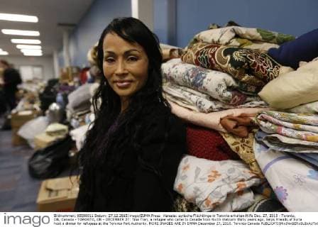 Kanada: syrische Flüchtlinge in Toronto erhalten Hilfe Dec. 27, 2015 - Toronto, ON, Canada - TORONTO, ON - DECEMBER 27: Tina Tran, a refugee who came to Canada from North Vietnam thirty years ago, helps Friends of Syria host a dinner for refugees at the Toronto Port Authority. MORE IMAGES ARE IN EMMA December 27, 2015. Toronto Canada  - ZUMAt14_