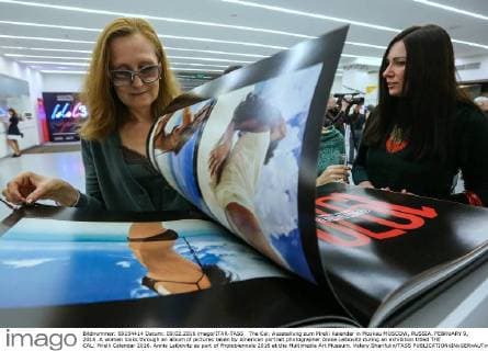 The Cal: Ausstellung zum Pirelli Kalender in Moskau MOSCOW, RUSSIA. FEBRUARY 9, 2016. A woman looks through an album of pictures taken by American portrait photographer Annie Leibovitz during an exhibition titled THE CAL: Pirelli Calendar 2016. Annie Leibovitz as part of Photobiennale 2016 at the Multimedia Art Museum. Valery Sharifulin TASS  TS016E20