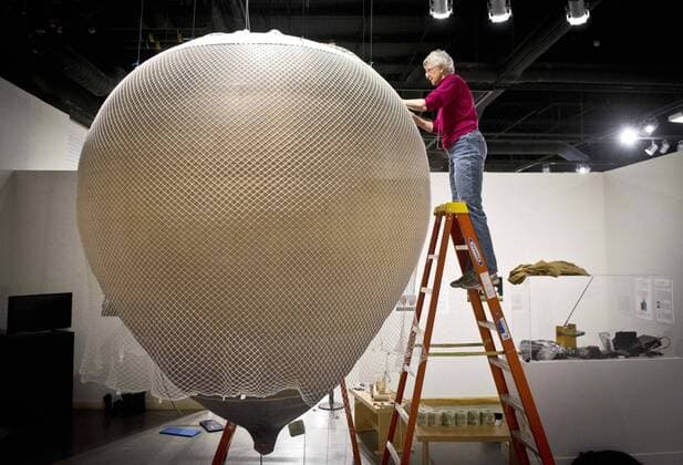 Feb. 19, 2016 - Albuquerque, NM, U.S. - 021816.Barbara Fricke, a gas and hot air balloon pilot, weaves the net over a 1 8th size replica of The Eagle, a Swedish gas balloon flown by Salomon A. Andree in 1897, at the Anderson Abruzzo International Balloon Museum, Friday, Feb. 19, 2016. The three-person crew of The Eagle were trying to get to the North Pole. The crew never made it, but their story was discovered 30 years after their deaths when they were found with undeveloped film and diaries. The net attaches the balloon to the gondola. The exhibit, Arctic Air: The Bold Flight of S. A. Andree , is expected to open this summer. Albuquerque U.S. - ZUMAab1_