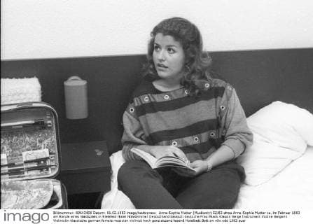 Anne-Sophie Mutter (Musikerin) 02 83 stroe Anne-Sophie Mutter ca. im Februar 1983 am Rande eines Gastspiels in Bielefeld Hotel Hotelzimmer Deutschland deutsch deutsche Frau Musik Klassik Geige Instrument Violine Geigerin Violinistin klassische german female musician violinist hoch ganz sitzend lesend Hotelbett Bett sw