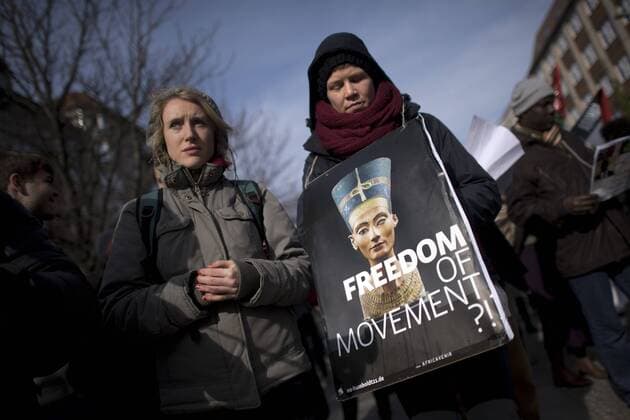 Gedenkmarsch Kolonialgeschichte DEU, Deutschland, Germany, Berlin, 27.02.2016 Demonstrant mit Plakat Freedom of Movement und Foto der Nofretete gegen die Kolobialgeschichte und die Aneigung afrikanischer Kulturgueter durch deutsche Museen und dem Humboldt Forum beim 10. Gedenkmarsch zur Erinnerung an die afrikanischen Opfer von Versklavung, Kolonialismus und rassistischer Gewalt vom Komitee fuer ein afrikanisches Denkmal in Berlin und afrikanischer Vereine in Berlin. Dieser Gedenkmarsch wurde ins Leben gerufen, um der Forderung nach Anerkennung der Verbrechen gegen Schwarze Menschen und Menschen afrikanischer Herkunft Nachdruck zu verleihen. Anlass ist die Berliner Afrika-Konferenz von 1884 - 1885, auf der Afrika vor 130 Jahren unter den europaeischen Kolonialmaechten aufgeteilt wurde. Mehr als 30 Millionen Afrikanerinnen und Afrikaner wurden Opfer von Versklavung und kolonialen Verbrech