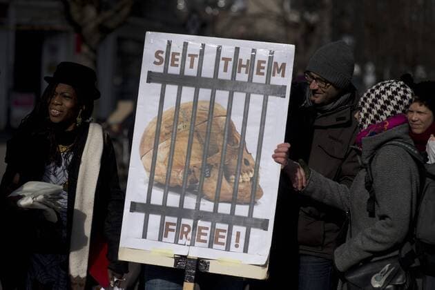 Gedenkmarsch Kolonialgeschichte DEU, Deutschland, Germany, Berlin, 27.02.2016 Demonstranten mit Plakat Voelkermord verjaehrt nicht und Set them Free beim 10. Gedenkmarsch zur Erinnerung an die afrikanischen Opfer von Versklavung, Kolonialismus und rassistischer Gewalt vom Komitee fuer ein afrikanisches Denkmal in Berlin und afrikanischer Vereine in Berlin. Dieser Gedenkmarsch wurde ins Leben gerufen, um der Forderung nach Anerkennung der Verbrechen gegen Schwarze Menschen und Menschen afrikanischer Herkunft Nachdruck zu verleihen. Anlass ist die Berliner Afrika-Konferenz von 1884 - 1885, auf der Afrika vor 130 Jahren unter den europaeischen Kolonialmaechten aufgeteilt wurde. Mehr als 30 Millionen Afrikanerinnen und Afrikaner wurden Opfer von Versklavung und kolonialen Verbrechen gegen die Menschlichkeit. Die von Deutschland an den Herero und Nama begangenen Voelkermorde in Namibia und di