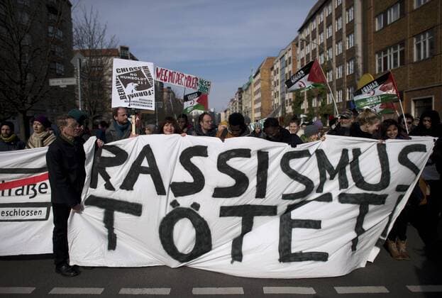 Gedenkmarsch Kolonialgeschichte DEU, Deutschland, Germany, Berlin, 27.02.2016 Demonstranten mit Transparent Rassismus toetet beim 10. Gedenkmarsch zur Erinnerung an die afrikanischen Opfer von Versklavung, Kolonialismus und rassistischer Gewalt vom Komitee fuer ein afrikanisches Denkmal in Berlin und afrikanischer Vereine in Berlin. Dieser Gedenkmarsch wurde ins Leben gerufen, um der Forderung nach Anerkennung der Verbrechen gegen Schwarze Menschen und Menschen afrikanischer Herkunft Nachdruck zu verleihen. Anlass ist die Berliner Afrika-Konferenz von 1884 - 1885, auf der Afrika vor 130 Jahren unter den europaeischen Kolonialmaechten aufgeteilt wurde. Mehr als 30 Millionen Afrikanerinnen und Afrikaner wurden Opfer von Versklavung und kolonialen Verbrechen gegen die Menschlichkeit. Die von Deutschland an den Herero und Nama begangenen Voelkermorde in Namibia und die Kriegsverbrechen in Ta