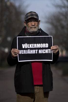 Gedenkmarsch Kolonialgeschichte DEU, Deutschland, Germany, Berlin, 27.02.2016 Demonstranten mit Plakat Voelkermord verjaehrt beim 10. Gedenkmarsch zur Erinnerung an die afrikanischen Opfer von Versklavung, Kolonialismus und rassistischer Gewalt vom Komitee fuer ein afrikanisches Denkmal in Berlin und afrikanischer Vereine in Berlin. Dieser Gedenkmarsch wurde ins Leben gerufen, um der Forderung nach Anerkennung der Verbrechen gegen Schwarze Menschen und Menschen afrikanischer Herkunft Nachdruck zu verleihen. Anlass ist die Berliner Afrika-Konferenz von 1884 - 1885, auf der Afrika vor 130 Jahren unter den europaeischen Kolonialmaechten aufgeteilt wurde. Mehr als 30 Millionen Afrikanerinnen und Afrikaner wurden Opfer von Versklavung und kolonialen Verbrechen gegen die Menschlichkeit. Die von Deutschland an den Herero und Nama begangenen Voelkermorde in Namibia und die Kriegsverbrechen in Ta