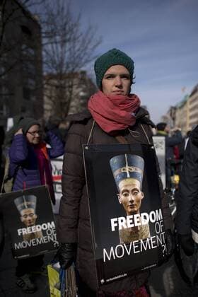 Gedenkmarsch Kolonialgeschichte DEU, Deutschland, Germany, Berlin, 27.02.2016 Demonstrant mit Plakat Freedom of Movement und Foto der Nofretete gegen die Kolobialgeschichte und die Aneigung afrikanischer Kulturgueter durch deutsche Museen und dem Humboldt Forum beim 10. Gedenkmarsch zur Erinnerung an die afrikanischen Opfer von Versklavung, Kolonialismus und rassistischer Gewalt vom Komitee fuer ein afrikanisches Denkmal in Berlin und afrikanischer Vereine in Berlin. Dieser Gedenkmarsch wurde ins Leben gerufen, um der Forderung nach Anerkennung der Verbrechen gegen Schwarze Menschen und Menschen afrikanischer Herkunft Nachdruck zu verleihen. Anlass ist die Berliner Afrika-Konferenz von 1884 - 1885, auf der Afrika vor 130 Jahren unter den europaeischen Kolonialmaechten aufgeteilt wurde. Mehr als 30 Millionen Afrikanerinnen und Afrikaner wurden Opfer von Versklavung und kolonialen Verbrech