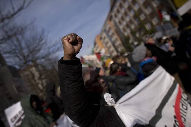Gedenkmarsch Kolonialgeschichte DEU, Deutschland, Germany, Berlin, 27.02.2016 Demonstranten afrikanischer Herrkunft mit geballter Faust beim Singen der suedafrikanischen Hymne beim 10. Gedenkmarsch zur Erinnerung an die afrikanischen Opfer von Versklavung, Kolonialismus und rassistischer Gewalt vom Komitee fuer ein afrikanisches Denkmal in Berlin und afrikanischer Vereine in Berlin. Dieser Gedenkmarsch wurde ins Leben gerufen, um der Forderung nach Anerkennung der Verbrechen gegen Schwarze Menschen und Menschen afrikanischer Herkunft Nachdruck zu verleihen. Anlass ist die Berliner Afrika-Konferenz von 1884 - 1885, auf der Afrika vor 130 Jahren unter den europaeischen Kolonialmaechten aufgeteilt wurde. Mehr als 30 Millionen Afrikanerinnen und Afrikaner wurden Opfer von Versklavung und kolonialen Verbrechen gegen die Menschlichkeit. Die von Deutschland an den Herero und Nama begangenen Voe