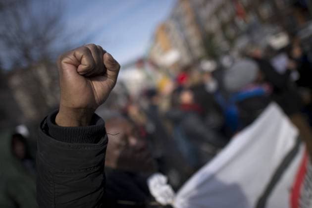 Gedenkmarsch Kolonialgeschichte DEU, Deutschland, Germany, Berlin, 27.02.2016 Demonstranten afrikanischer Herrkunft mit geballter Faust beim Singen der suedafrikanischen Hymne beim 10. Gedenkmarsch zur Erinnerung an die afrikanischen Opfer von Versklavung, Kolonialismus und rassistischer Gewalt vom Komitee fuer ein afrikanisches Denkmal in Berlin und afrikanischer Vereine in Berlin. Dieser Gedenkmarsch wurde ins Leben gerufen, um der Forderung nach Anerkennung der Verbrechen gegen Schwarze Menschen und Menschen afrikanischer Herkunft Nachdruck zu verleihen. Anlass ist die Berliner Afrika-Konferenz von 1884 - 1885, auf der Afrika vor 130 Jahren unter den europaeischen Kolonialmaechten aufgeteilt wurde. Mehr als 30 Millionen Afrikanerinnen und Afrikaner wurden Opfer von Versklavung und kolonialen Verbrechen gegen die Menschlichkeit. Die von Deutschland an den Herero und Nama begangenen Voe
