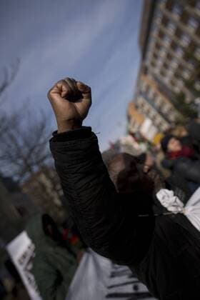 Gedenkmarsch Kolonialgeschichte DEU, Deutschland, Germany, Berlin, 27.02.2016 Demonstranten afrikanischer Herrkunft mit geballter Faust beim Singen der suedafrikanischen Hymne beim 10. Gedenkmarsch zur Erinnerung an die afrikanischen Opfer von Versklavung, Kolonialismus und rassistischer Gewalt vom Komitee fuer ein afrikanisches Denkmal in Berlin und afrikanischer Vereine in Berlin. Dieser Gedenkmarsch wurde ins Leben gerufen, um der Forderung nach Anerkennung der Verbrechen gegen Schwarze Menschen und Menschen afrikanischer Herkunft Nachdruck zu verleihen. Anlass ist die Berliner Afrika-Konferenz von 1884 - 1885, auf der Afrika vor 130 Jahren unter den europaeischen Kolonialmaechten aufgeteilt wurde. Mehr als 30 Millionen Afrikanerinnen und Afrikaner wurden Opfer von Versklavung und kolonialen Verbrechen gegen die Menschlichkeit. Die von Deutschland an den Herero und Nama begangenen Voe