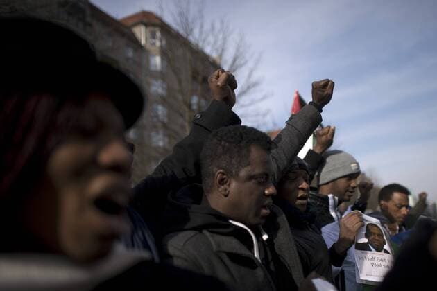 Gedenkmarsch Kolonialgeschichte DEU, Deutschland, Germany, Berlin, 27.02.2016 Demonstranten afrikanischer Herrkunft mit geballter Faust beim Singen der suedafrikanischen Hymne beim 10. Gedenkmarsch zur Erinnerung an die afrikanischen Opfer von Versklavung, Kolonialismus und rassistischer Gewalt vom Komitee fuer ein afrikanisches Denkmal in Berlin und afrikanischer Vereine in Berlin. Dieser Gedenkmarsch wurde ins Leben gerufen, um der Forderung nach Anerkennung der Verbrechen gegen Schwarze Menschen und Menschen afrikanischer Herkunft Nachdruck zu verleihen. Anlass ist die Berliner Afrika-Konferenz von 1884 - 1885, auf der Afrika vor 130 Jahren unter den europaeischen Kolonialmaechten aufgeteilt wurde. Mehr als 30 Millionen Afrikanerinnen und Afrikaner wurden Opfer von Versklavung und kolonialen Verbrechen gegen die Menschlichkeit. Die von Deutschland an den Herero und Nama begangenen Voe