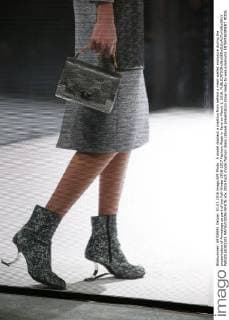 A model displays a creation from behind a mesh-walled enclosure during the presentation of Anrealage as part of the Fall-Winter 2016-2017 Fashion Week in Paris on March 1, 2016.  PAR20160301105 MAYAxVIDON-WHITE