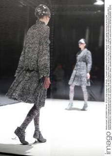 A model displays a creation from behind a mesh-walled enclosure during the presentation of Anrealage as part of the Fall-Winter 2016-2017 Fashion Week in Paris on March 1, 2016.  PAR20160301107 MAYAxVIDON-WHITE
