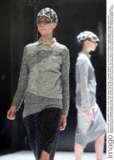 A model displays a creation from behind a mesh-walled enclosure during the presentation of Anrealage as part of the Fall-Winter 2016-2017 Fashion Week in Paris on March 1, 2016.  PAR20160301108 MAYAxVIDON-WHITE