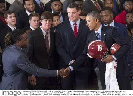 President Barack Obama shakes hands with 2015 Heinemann trophy winner Derrick Henry, as Henry and other team captain give President Obama a helmet an jersey as Obama honors the 2015- 2016 College Football Playoff National Champion Alabama Crimson Tide, in the East Room at the White House in Washington, D.C. on March 2, 2016.  WAP20160302340 KEVINxDIETSCH