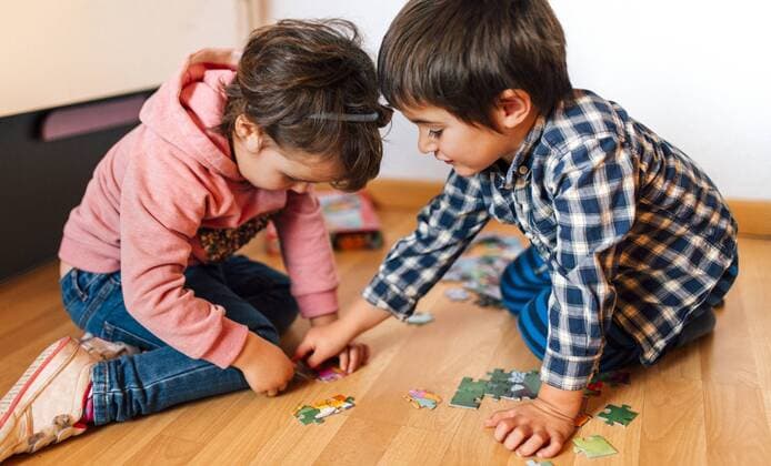 Boy and girl doing a jigsaw on the floor together model released Symbolfoto property released  MGOF001418