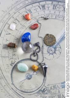 IMAGO Creative, Lifestyle, Esoterik gefährlicher Glaube Semiprecious stones, pendulum, pendant and crystal ball on horoscope circle  MYF001325