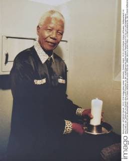 IMAGO History, Ende der Apartheid in Südafrika: 1990-1994 Kapstadt, Robben Island, 25.02.2016 Robben Island (afrikaans: Robbeneiland) ist eine Insel in der Tafelbucht im Atlantik etwa zwölf Kilometer vor der südafrikanischen Küstenstadt Kapstadt und 6,9 km vom nächstgelegenen Festlandsabschnitt bei Bloubergstrand. Die frühere Gefängnisinsel wurde Mitte der 1990er Jahre zu einem Natur- und Nationaldenkmal, das frühere Gefängnisgebäude zu einem Museum umgestaltet. In dem einstigen Gefängnis hatte Nelson Mandela 18 Jahre als Häftling in einer vier Quadratmeter großen Einzelzelle verbracht. Foto: Nelson Mandela zuendet Kerze in seiner alten Zelle an (Repro) Cape Town, Robben Iceland, 02 25 2016 Robben Iceland (Afrikaans: Robben Iceland) is an island in Table Bay in the Atlantic about twelve kilometers off the South African coastal city of Cape Town and 6.9 km from the nearest mainland section at Bloubergstrand. The former prison island was redesi