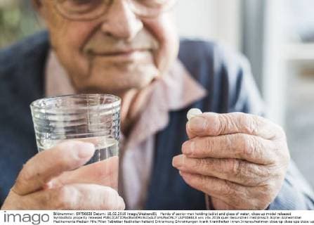 Hands of senior man holding tablet and glass of water, close up model released Symbolfoto property released  UUF006618