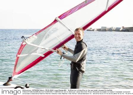 Smiling man windsurfing on the sea model released Symbolfoto  VABF000103