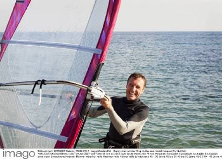 Happy man windsurfing on the sea model released Symbolfoto  VABF000106