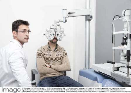 Model Released: Augenarzt Optometrist examining eyesight of a man model released Symbolfoto property released  ERLF000124