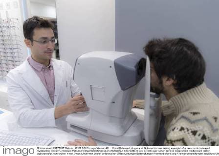 Model Released: Augenarzt Optometrist examining eyesight of a man model released Symbolfoto property released  ERLF000126