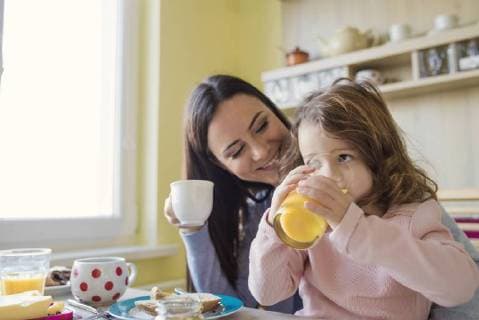 Mother and her little daughter together at breakfast table model released Symbolfoto property released  HAPF000121