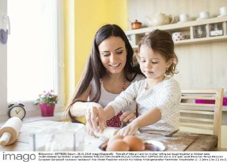 Portrait of little girl and her mother rolling out dough together on kitchen table model released Symbolfoto property released  HAPF000140