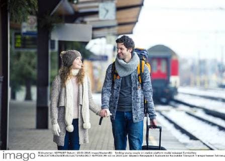 IMAGO Creative: Countdown bis Weihnachten, Nach Hause reisen Smiling young couple on station platform model released Symbolfoto  HAPF000199