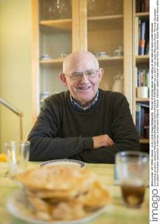 Portrait of smiling senior man sitting at laid table at home model released Symbolfoto property released  RAEF000857