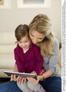 Mother and her little daughter looking at digital tablet model released Symbolfoto property released  SHKF000442