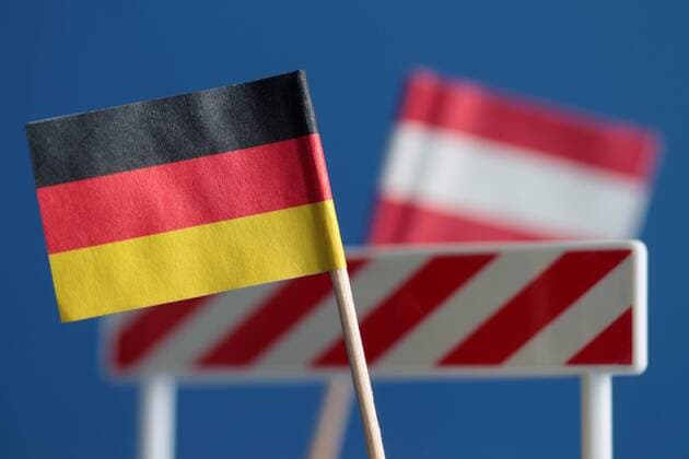 Symbolbild Grenzkontrollen und Aussetzung des Schengen Raum s während der anhaltenden Flüchtlingskrise in der EU Europäische n Union: Flagge Deutschland s und Schlagbaum mit Flagge Österreich s dahinter