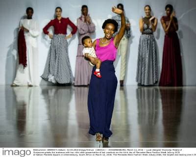 (160312) -- JOHANNESBURG, March 12, 2016 -- Local designer Khomotjo Malatji of Grapevine greets the audience with her child after presentation of her creations on the third day of Mercedes-Benz Fashion Week Joburg 2016 at Nelson Mandela Square in Johannesburg, South Africa on March 12, 2016. The Mercedes-Benz Fashion Week Joburg 2016, the largest and leading one in Africa, closed here Saturday. Creations by nearly 20 South African fashion designers have been presented in 14 shows of the past three days. ) SOUTH AFRICA-JOHANNESBURG-FASHION WEEK-CLOSING ZhaixJianlan 