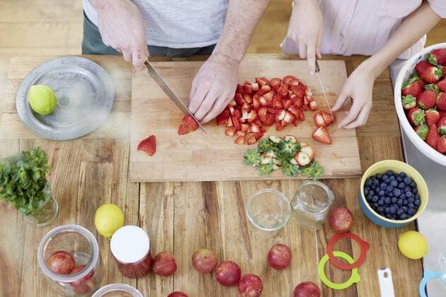 Couple cutting strawberries in kitchen model released Symbolfoto property released  FMKF002390