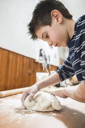 Boy kneading dough on kitchen worktop model released Symbolfoto  DEGF000655