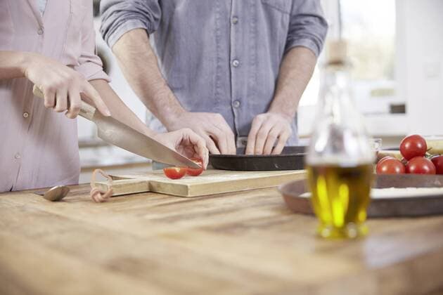 Couple cutting tomatoes in kitchen model released Symbolfoto property released  FMKF002357